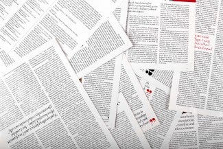 A number of journal pages filled with text are spread out, overlapping each other