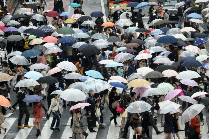 People crossing the road holding umbrellas