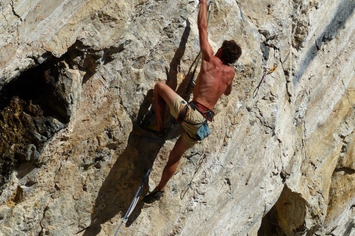 a person scaling a rock face with no ropes