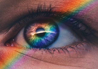 Close up of eye with rainbow arcing across face