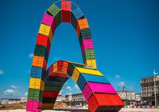 A sculpture made of two arcs of shipping containers