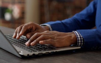 hands typing on a laptop