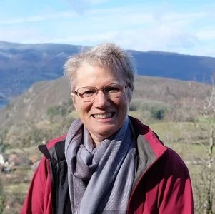 An image of a smiling woman standing in the outdoors