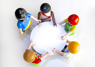 five playmobil figures around a circular table